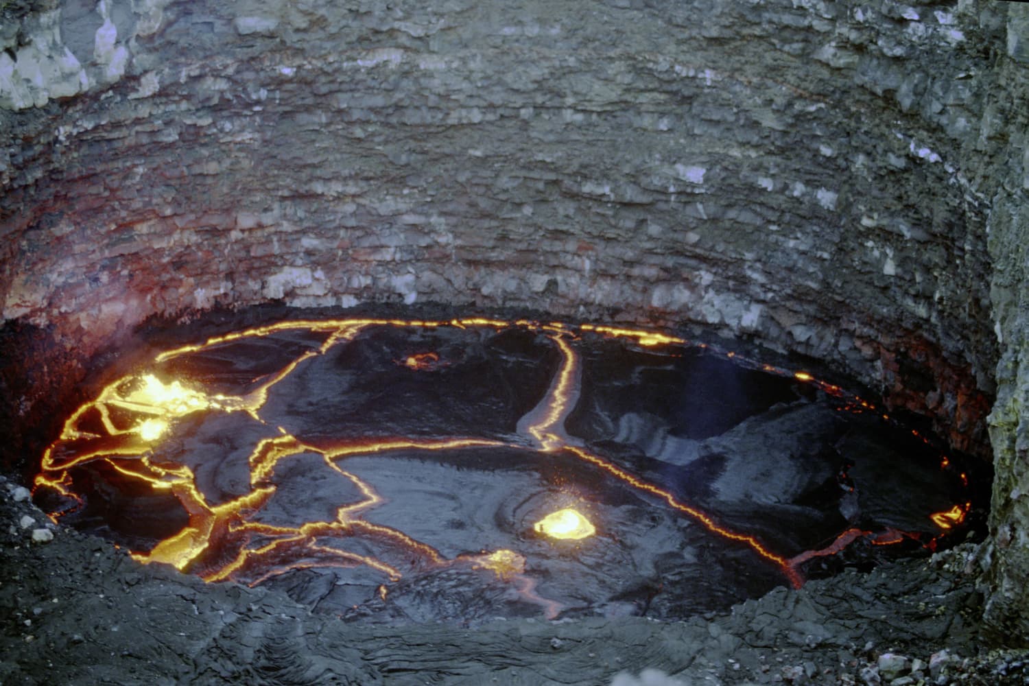 The black crust of the Erta Ale lava lake laced with glowing orange cracks