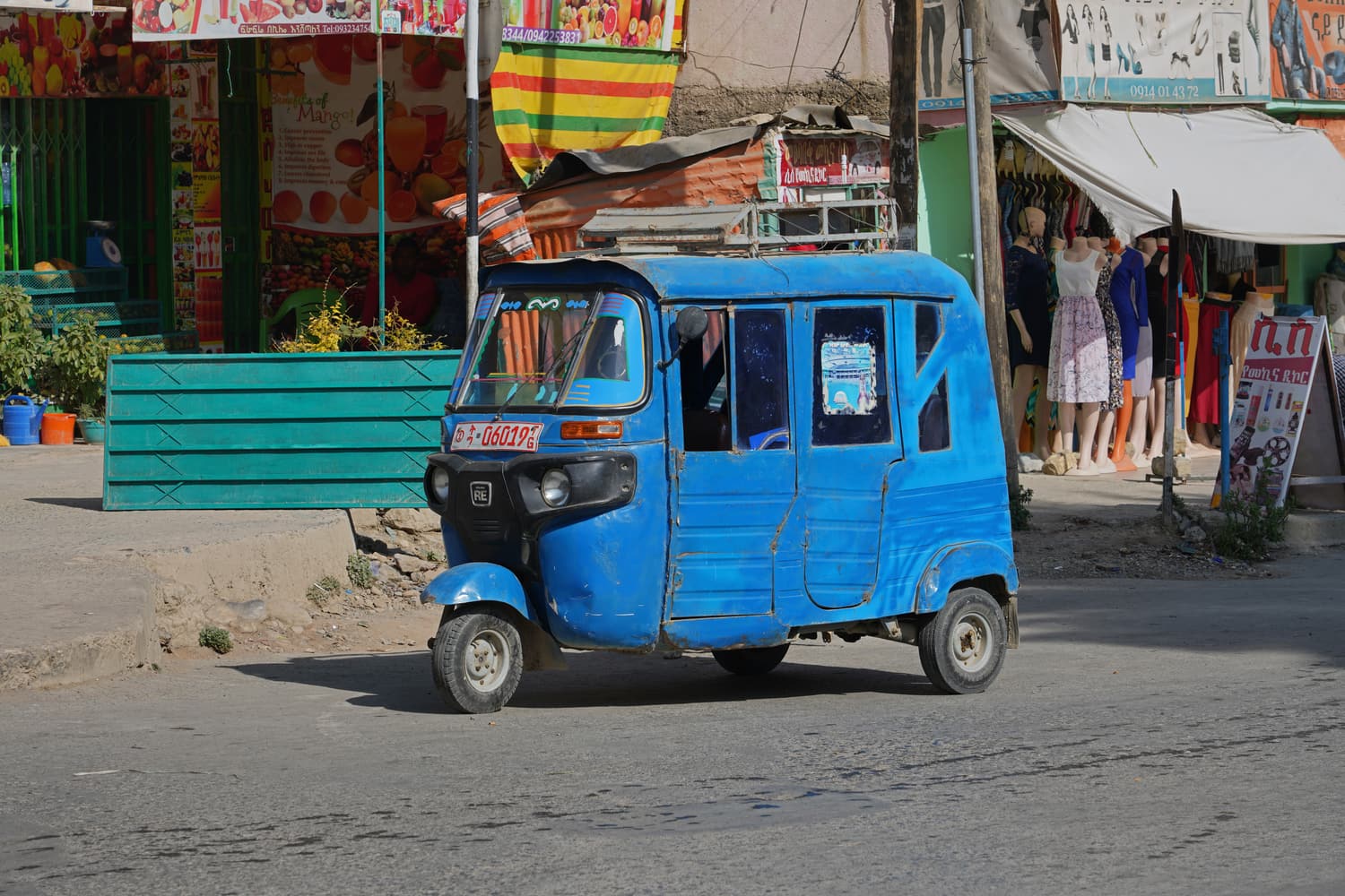 A blue tuk-tuk on a street in central Mekele