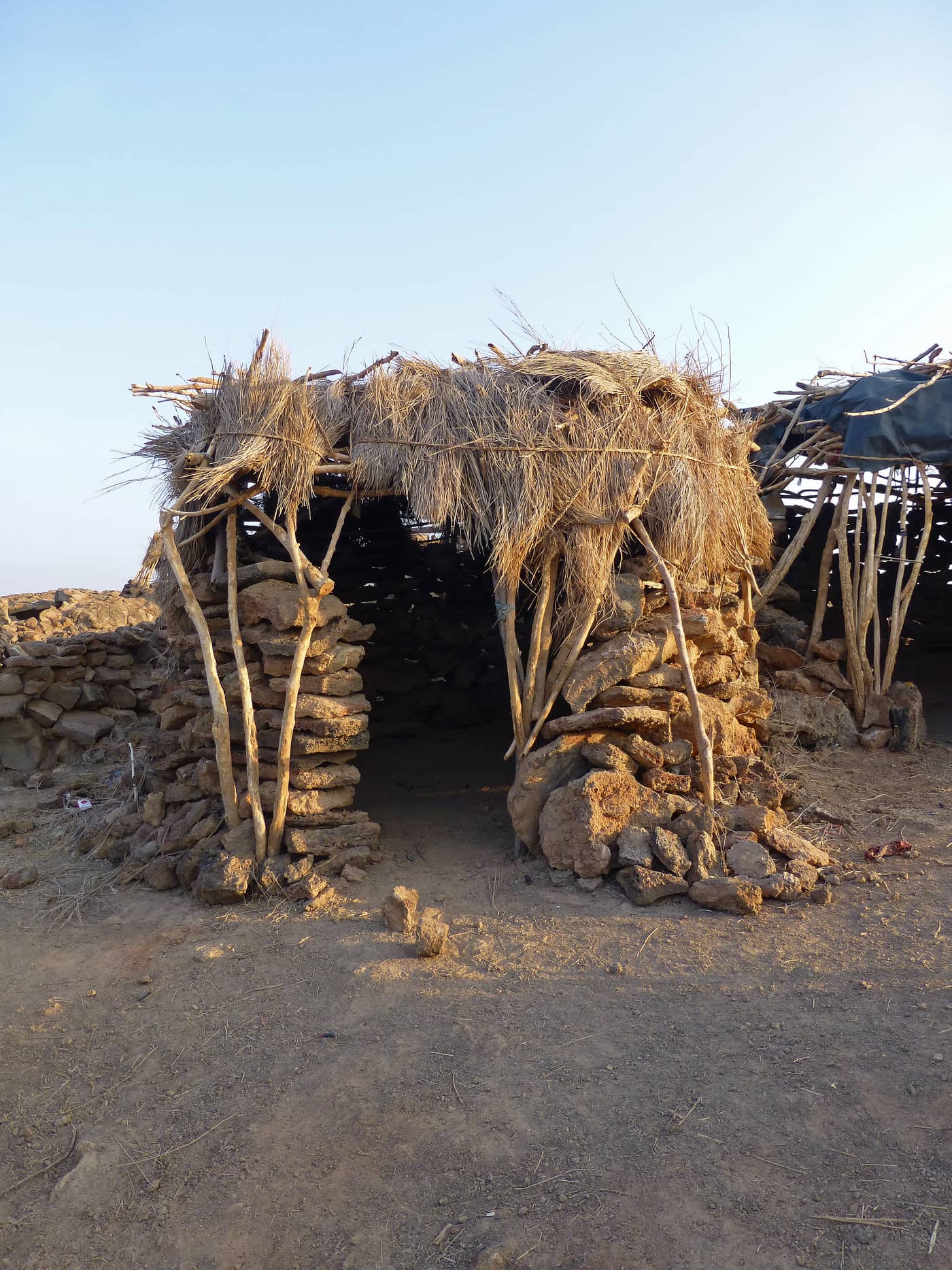 Simple stone-and-thatch shelters at the Erta Ale base camp