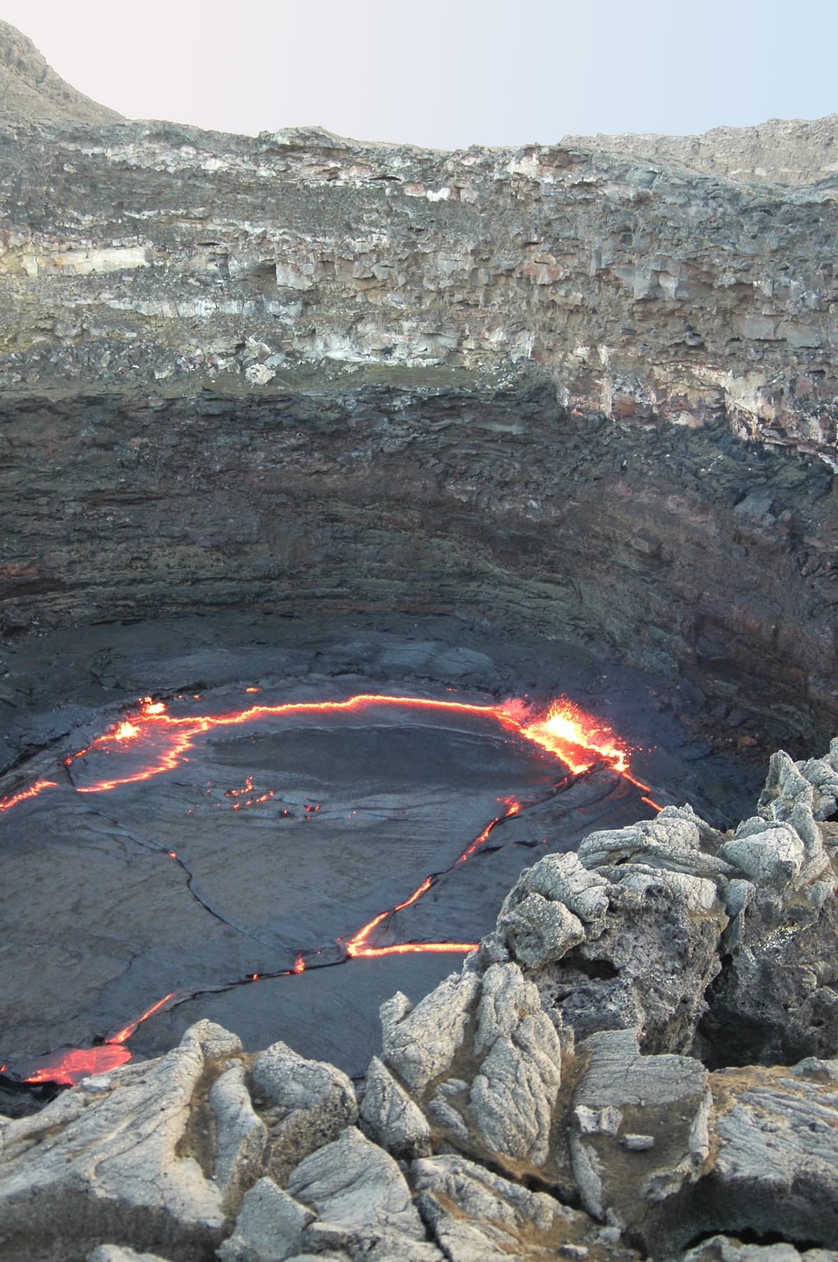 The deep pit crater of Erta Ale with a thin ring of glowing lava at its bottom